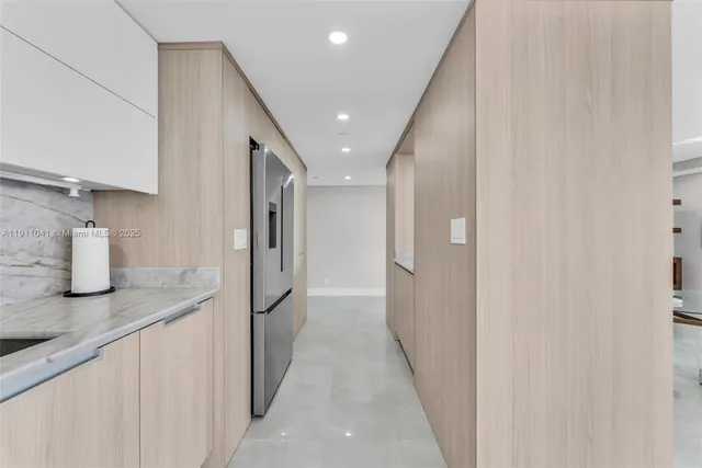 a hallway with stainless steel appliances granite countertop furniture and a kitchen view