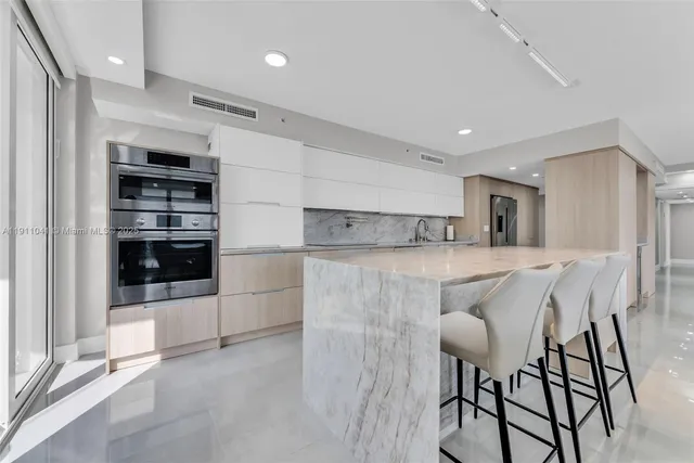 a kitchen with cabinets and chairs