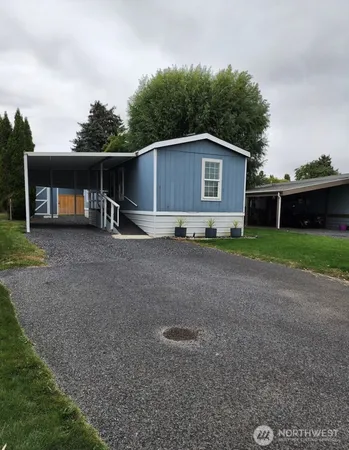 a view of a house with a yard and large trees