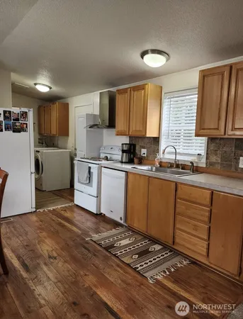 a kitchen with a sink appliances cabinets and a counter top space