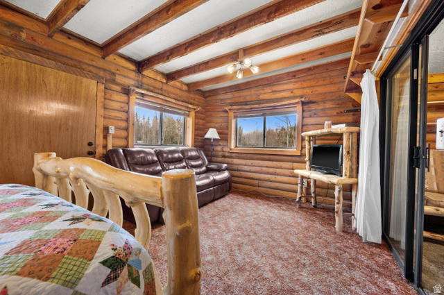 4725 Pine Ridge Road Evanston, UT 82930 - Photo 32 of 82 Rustic interior featuring natural wood log walls and exposed beam ceilings