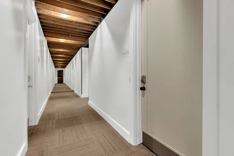 a view of a hallway with wooden floor and entryway