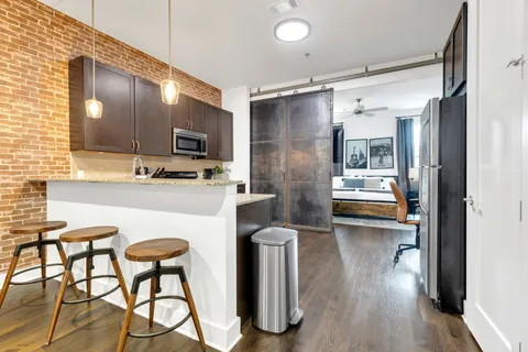 a kitchen with stainless steel appliances kitchen island granite countertop a refrigerator and a stove top oven