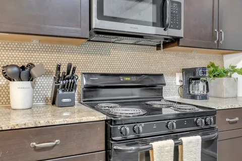 a kitchen with granite countertop stainless steel appliances and cabinets
