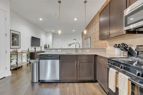 a kitchen with stainless steel appliances granite countertop a stove a sink and a microwave