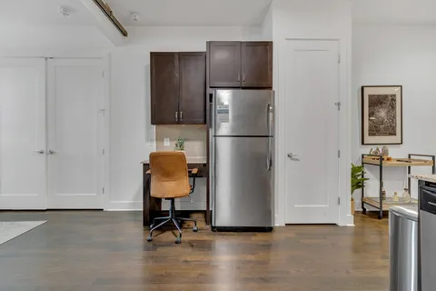 a view of a workspace with furniture and wooden floor