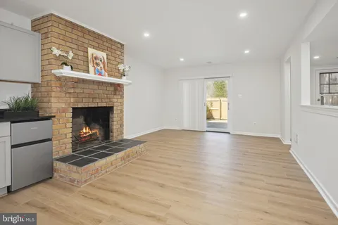 a view of an empty room with a fireplace and a window