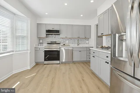 a kitchen with stainless steel appliances granite countertop a stove a refrigerator and a sink