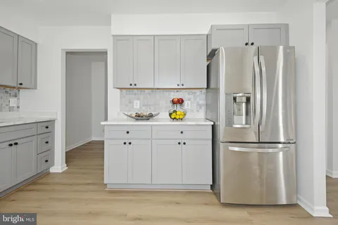 a kitchen with cabinets stainless steel appliances and wooden floor