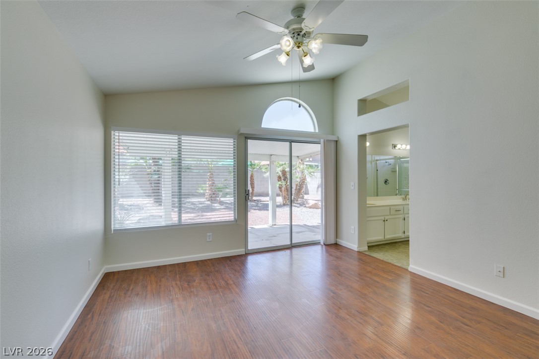 307 Cavalla Street Henderson, NV 89074 - Photo 35 of 44 Vast hardwood floors and high ceilings create an airy ambiance within this generous primary bedroom, offering direct outdoor access.