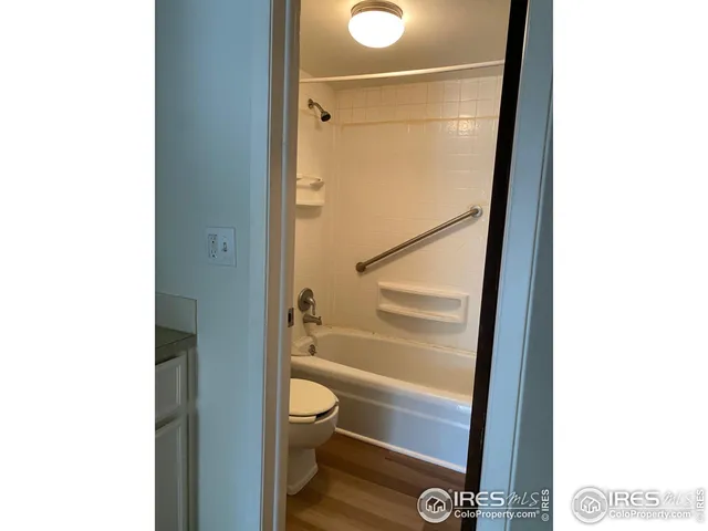 a bathroom with a granite countertop bathtub shower and toilet