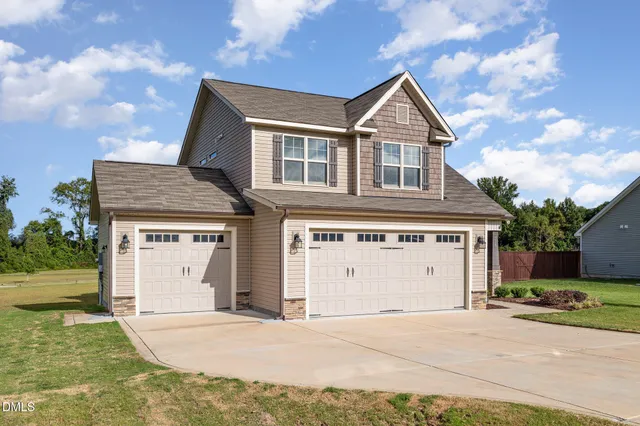 a front view of a house with a yard and garage