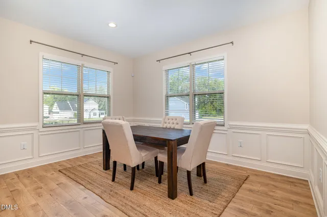 a dining room with wooden floor and a window