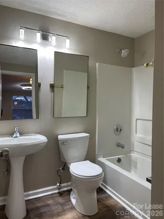 a bathroom with a toilet a sink a mirror and bathtub