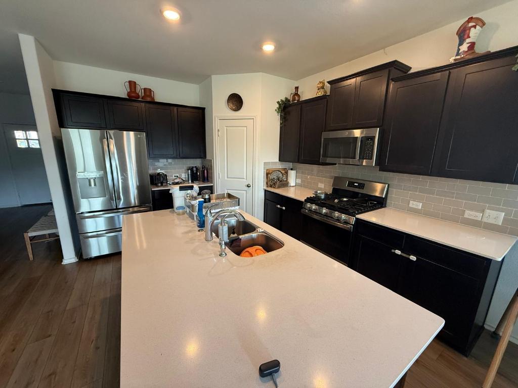 380 Mendoza Kyle, TX 78640 - Photo 8 of 28 a kitchen with stainless steel appliances a refrigerator sink and microwave
