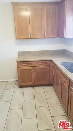 a kitchen with granite countertop a sink a stove and cabinets