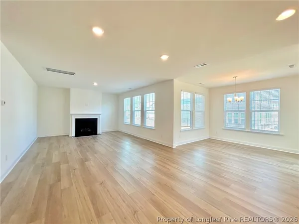 a view of empty room with wooden floor and fireplace