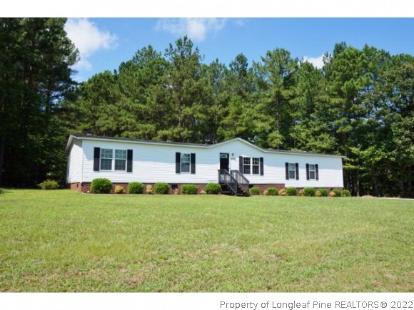 2972 Underwood Road Carthage, NC 28327 - Photo 1 of 24 a house that is sitting in the grass with large trees and plants