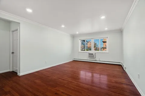 a view of a big room with wooden floor and window