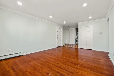 a view of empty room with wooden floor