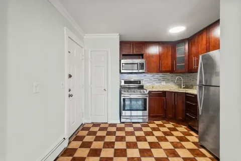 a kitchen with granite countertop a refrigerator and a stove top oven