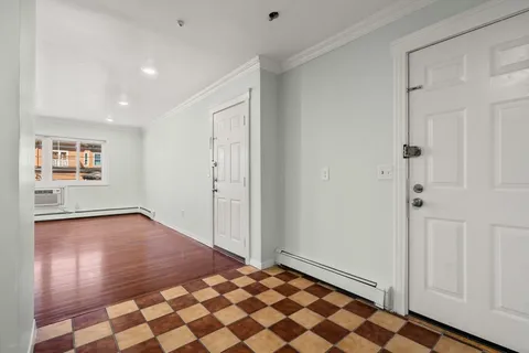 a view of a room with wooden floor and white walls