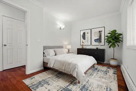 a bedroom with a bed and a potted plant