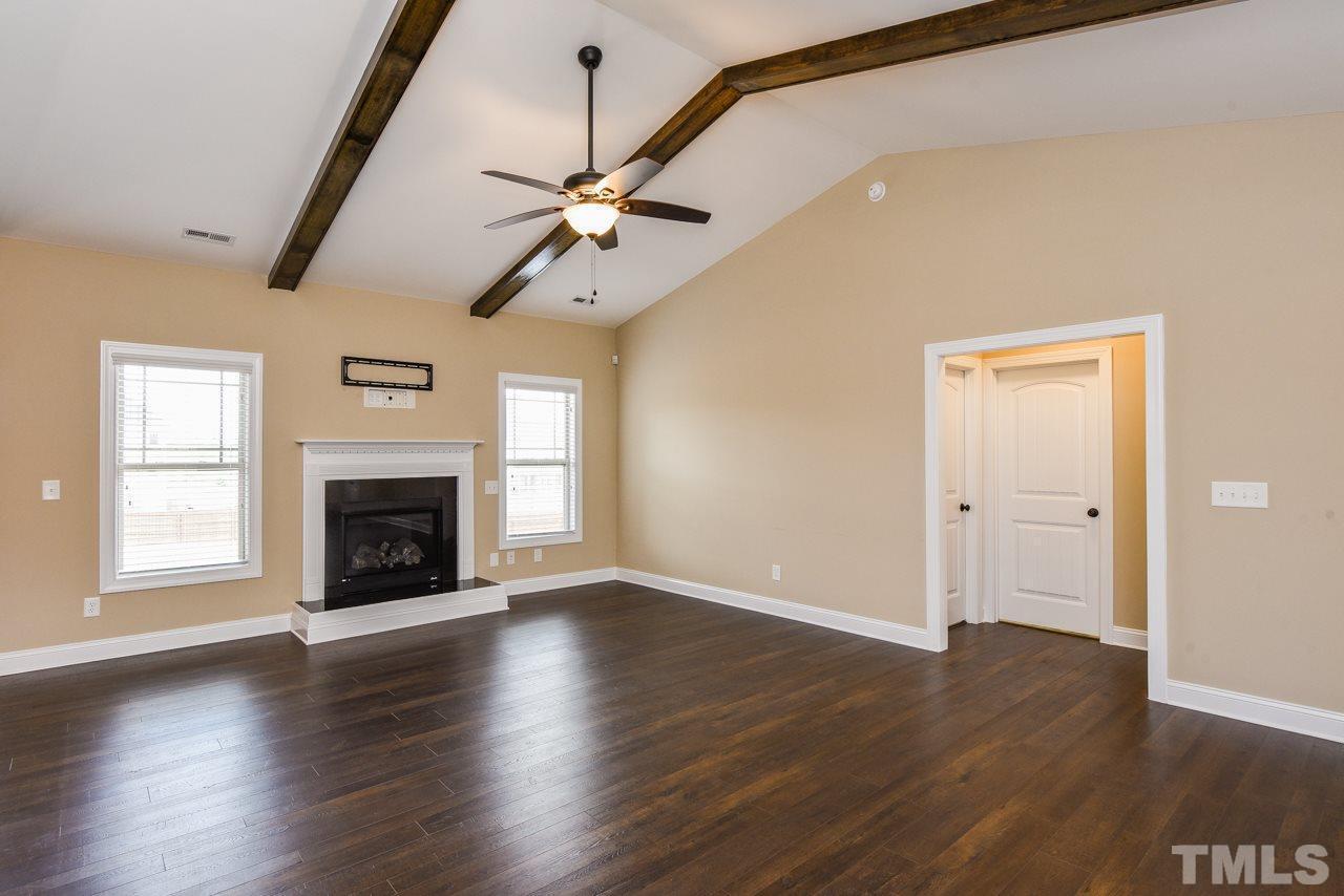43 Sharpstone Lane Clayton, NC 27527 - Photo 13 of 39 an empty room with wooden floor fireplace and windows
