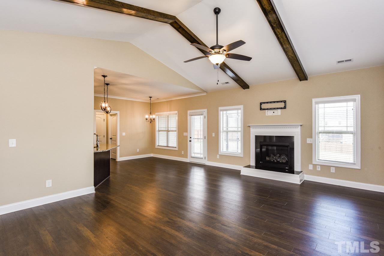 43 Sharpstone Lane Clayton, NC 27527 - Photo 15 of 39 an empty room with wooden floor fireplace and windows