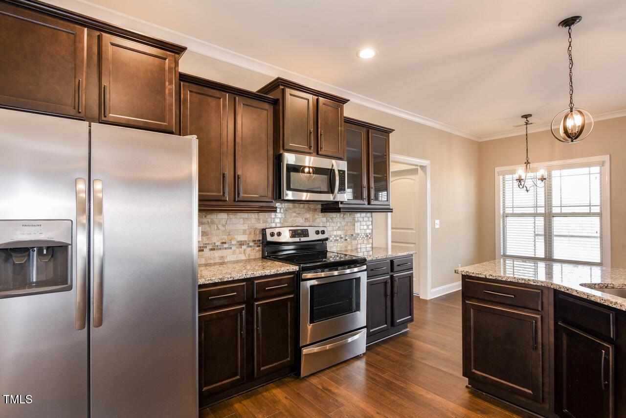43 Sharpstone Lane Clayton, NC 27527 - Photo 36 of 39 a kitchen with stainless steel appliances granite countertop a refrigerator stove and microwave