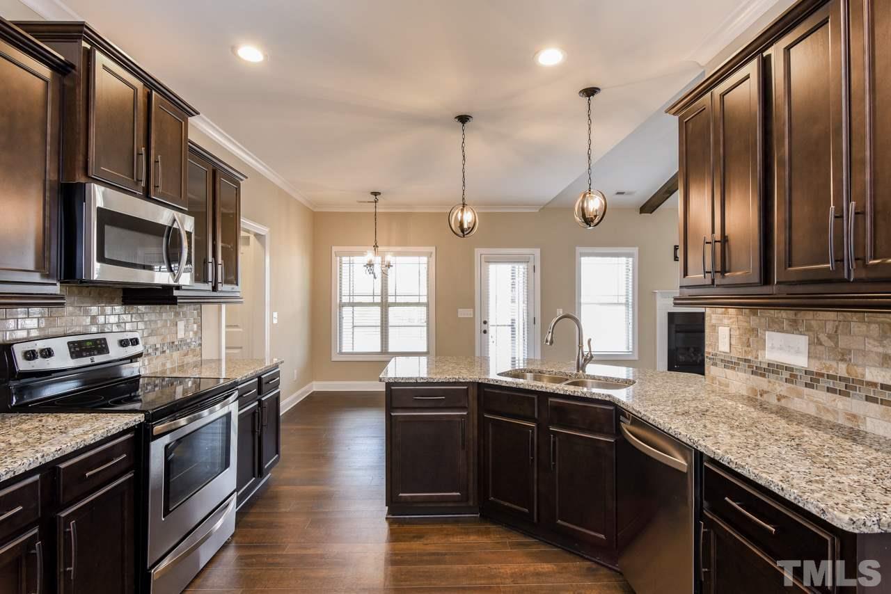 43 Sharpstone Lane Clayton, NC 27527 - Photo 7 of 39 a kitchen with stainless steel appliances granite countertop a sink a stove and a wooden floors