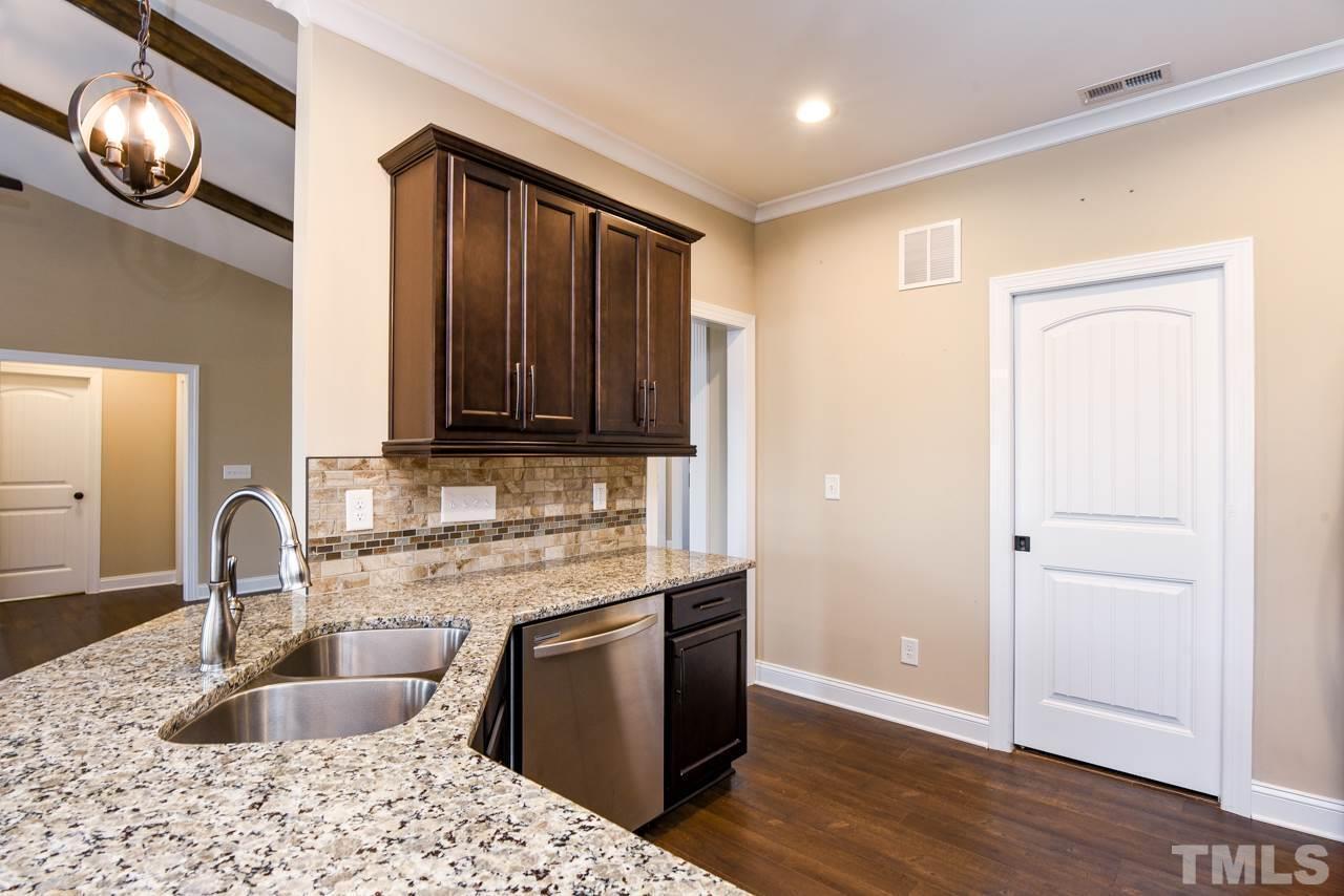 43 Sharpstone Lane Clayton, NC 27527 - Photo 8 of 39 a kitchen with granite countertop wooden cabinets and a sink