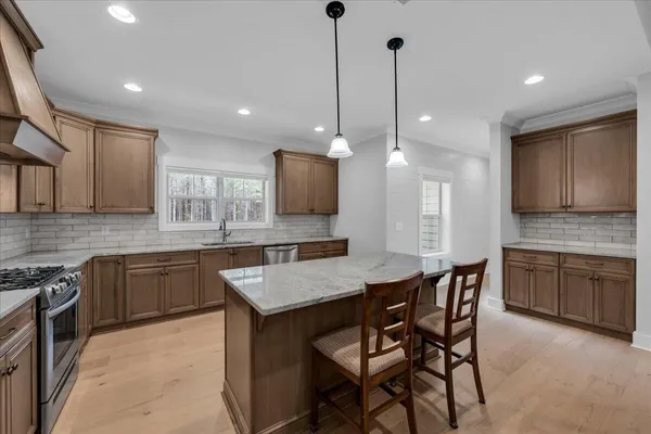 a kitchen that has a lot of cabinets and stainless steel appliances
