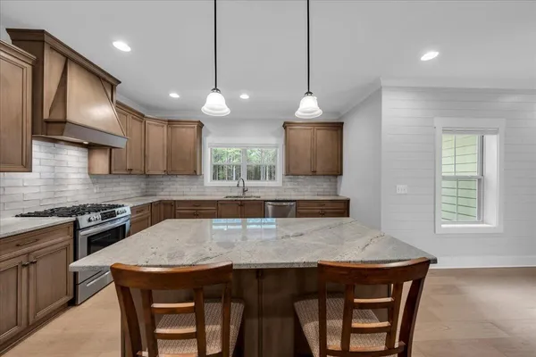 a kitchen with stainless steel appliances granite countertop a stove and a refrigerator