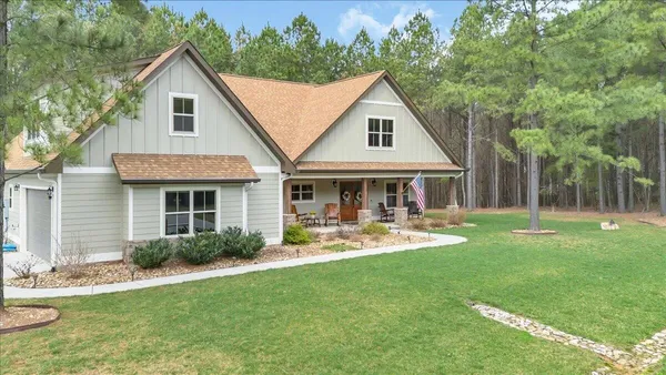 a front view of a house with yard and green space