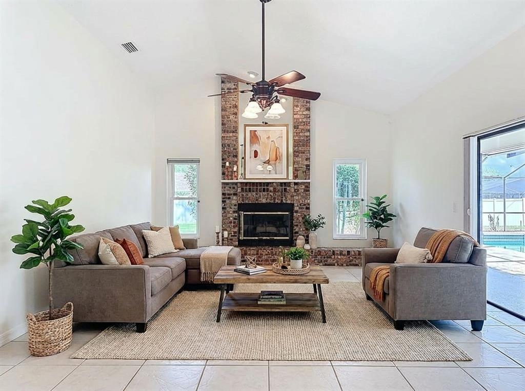 2414 Buckhorn Run Drive Valrico, FL 33596 - Photo 21 of 50 a living room with furniture a fireplace and a chandelier