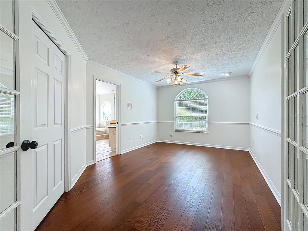 2414 Buckhorn Run Drive Valrico, FL 33596 - Photo 29 of 50 an empty room with wooden floor chandelier fan and windows