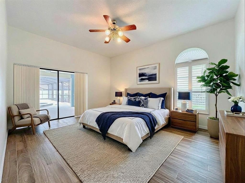 2414 Buckhorn Run Drive Valrico, FL 33596 - Photo 10 of 50 a spacious bedroom with a large bed a chandelier and windows