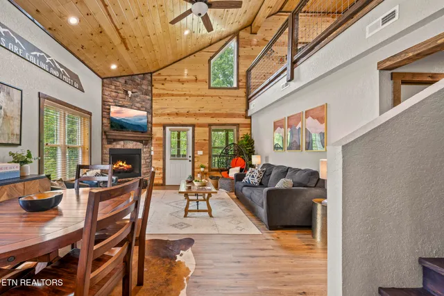 a kitchen with stainless steel appliances lots of wooden furniture dining table and chairs