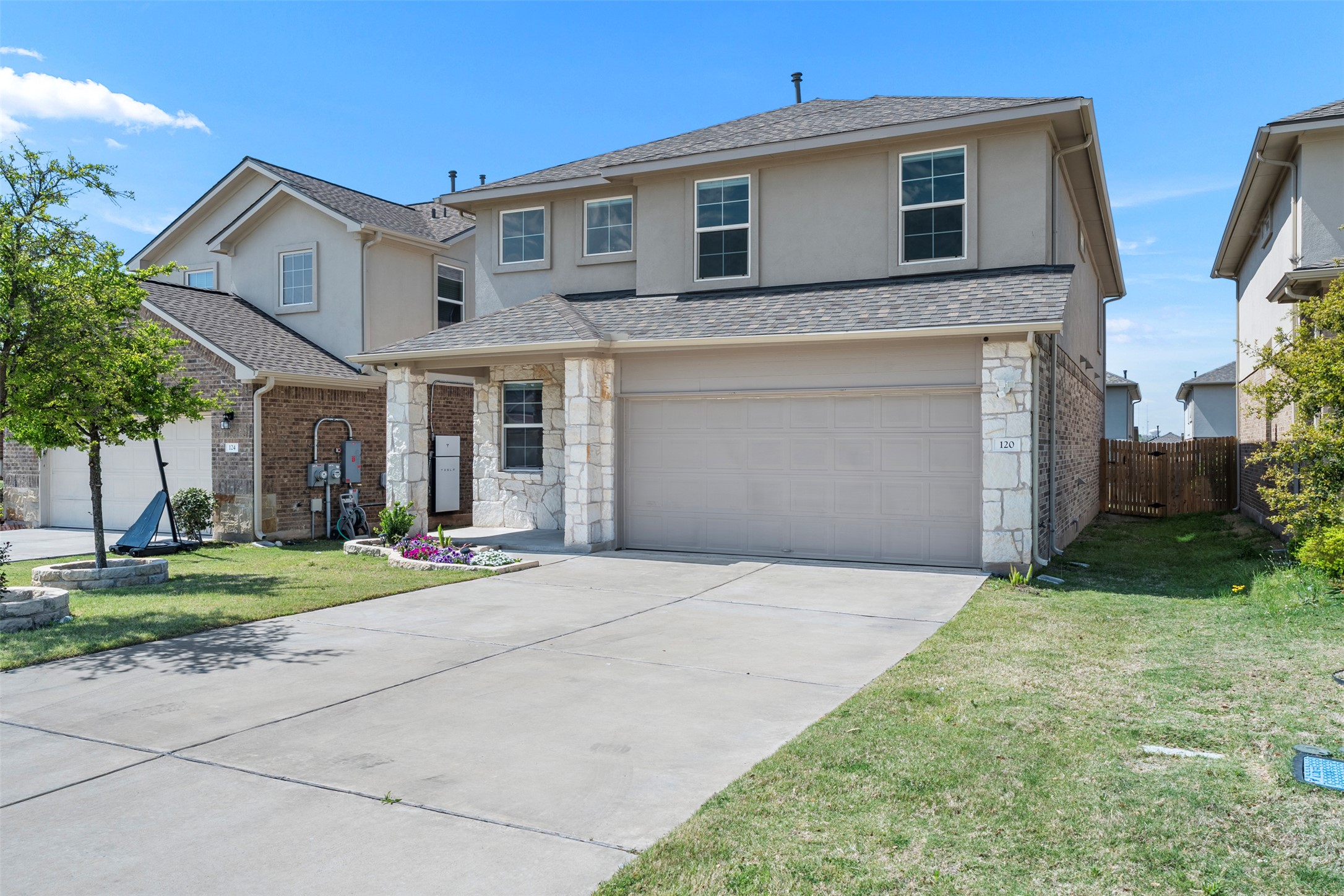 120 Ellinger Road Georgetown, TX 78626 - Photo 10 of 28 Two-story stucco and stone exterior featuring a two-car garage, concrete driveway, and covered entry