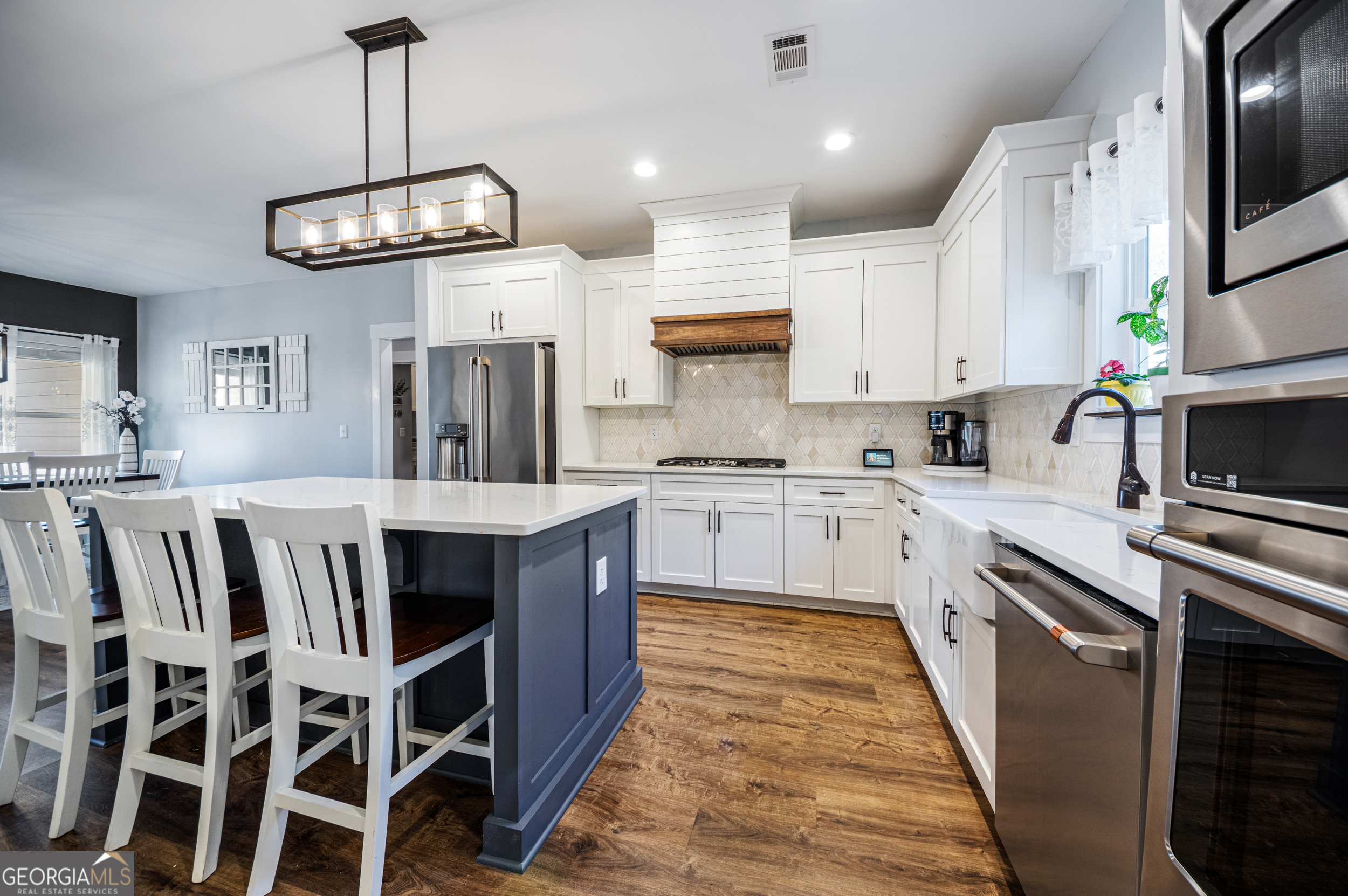 2736 Jones Holly Road Good Hope, GA 30641 - Photo 12 of 49 a kitchen with a kitchen island wooden floor stainless steel appliances cabinets and a counter top space