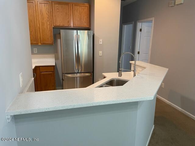 12301 Kernan Forest Boulevard, Unit 302 Jacksonville, FL 32225 - Photo 14 of 14 a kitchen with a refrigerator and a sink