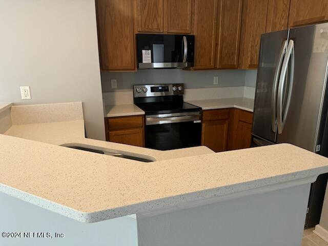 12301 Kernan Forest Boulevard, Unit 302 Jacksonville, FL 32225 - Photo 6 of 14 a kitchen with a refrigerator stove and microwave