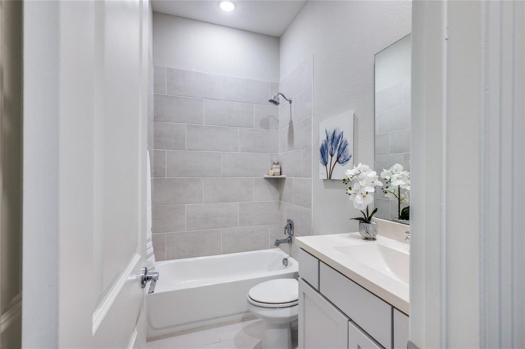 1309 Old Rocksprings Pass Mansfield, TX 76063 - Photo 9 of 36 Bathroom featuring a white tub, shower with light gray subway tile surround, recessed lighting, and a white vanity with an integrated sink and mirror