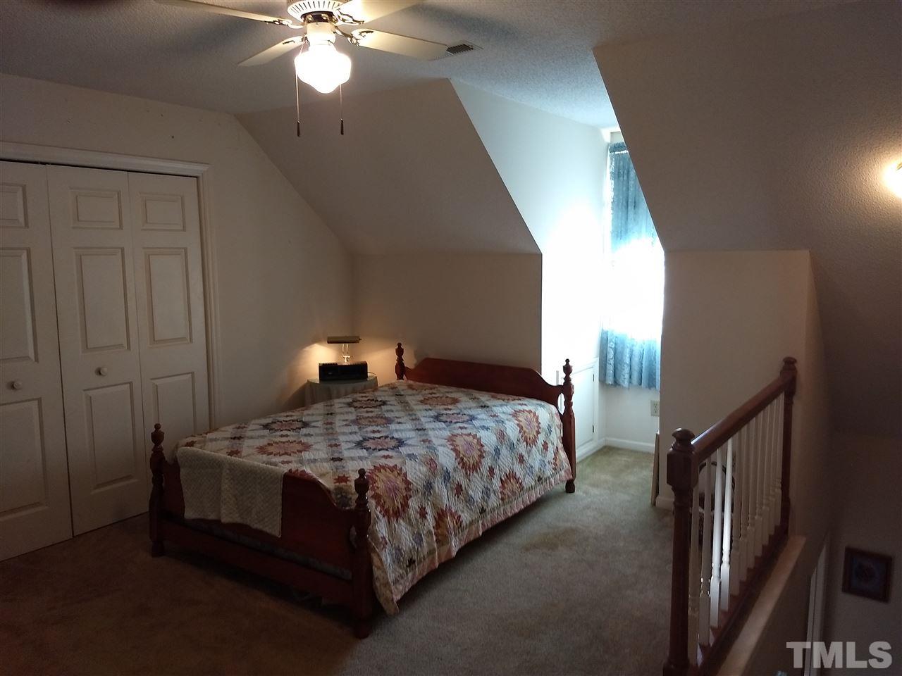 4404 Liverpool Lane Raleigh, NC 27604 - Photo 17 of 18 a bedroom with a bed and a chandelier