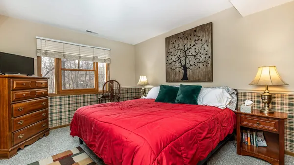 a bedroom with a bed and a flat tv screen on dresser