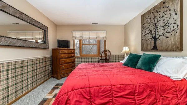 a bedroom with bed and a flat tv screen on dresser