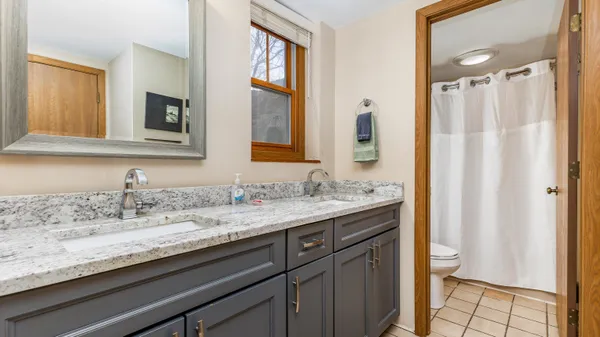 a bathroom with a granite countertop sink a toilet and a mirror