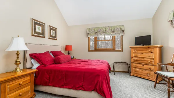 a bedroom with a bed and a flat tv screen on the dresser