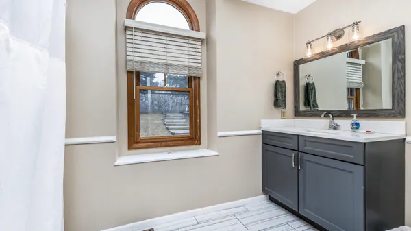 a bathroom with a sink a mirror and a window